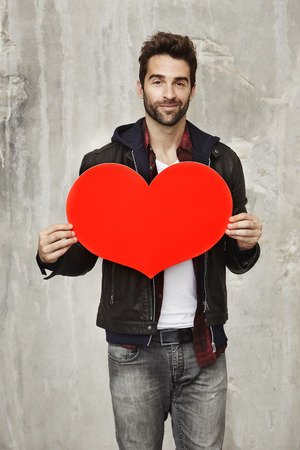 Dude holding valentine heart, portraitの写真素材
