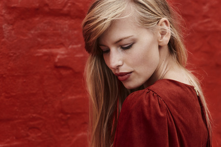 Gorgeous blond woman in red dress, looking downの写真素材