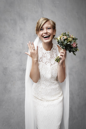 Surprised beauty bride holding flowers, portraitの写真素材