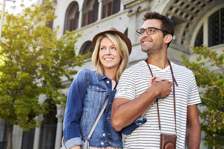 Smiling couple walking through city, smilingの写真素材