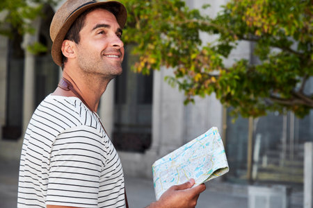 Man with a map looking up, smiling