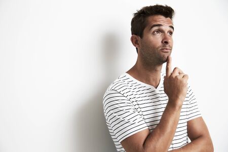 Thoughtful guy in studio, looking upの写真素材