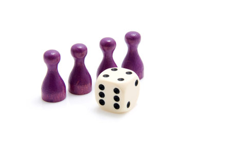 four purple pawns and one dice isolated on white backgroundの写真素材