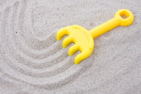 plastic rake in sandの写真素材