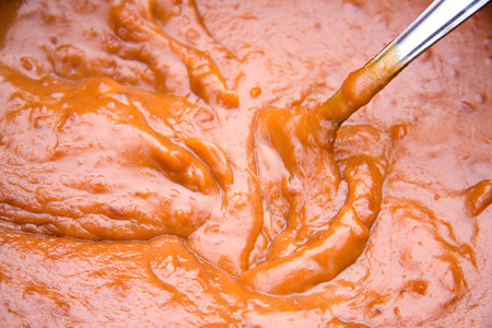 spoon in satay sauce in closeup