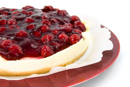 Cherry and cheese pie on red plate over white backgroundの写真素材