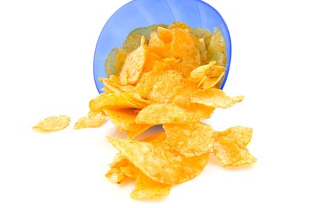 potato chips falling out of blue plastic bowl, isolated on white backgroundの写真素材