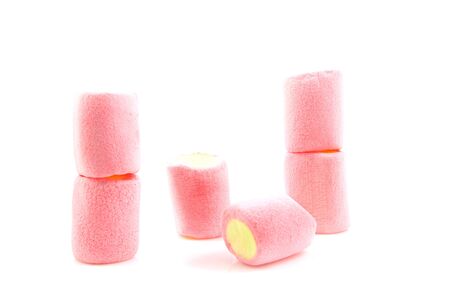 stack of colorful marshmallows in yellow and pink over white backgroundの写真素材