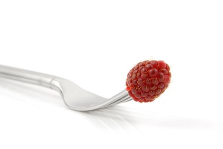 Fresh raspberry on fork in closeup isolated on white backgroundの写真素材