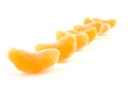 slices of mandarin in a row isolated on white backgroundの写真素材