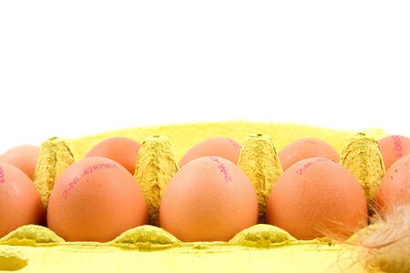ten chicken eggs in yellow box over white backgroundの写真素材