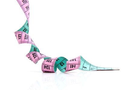 pink and green measure tape over white backgroundの写真素材