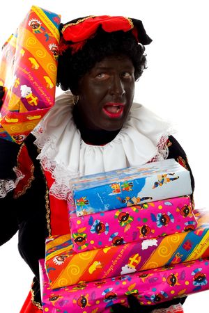 Zwarte piet ( black pete) typical Dutch character part of a traditional event celebrating the birthday of  Sinterklaas in december over white background holding presentsの写真素材