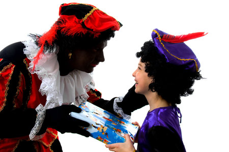 Zwarte piet ( black pete) typical Dutch character part of a traditional event celebrating the birthday of  Sinterklaas in december over white background with young childの写真素材