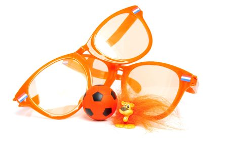 Orange soccer accessory: big glasses, ball and Dutch lion over white backgroundの写真素材