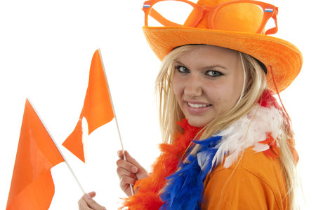 portrait of Dutch soccer fan in orange outfit with flags over white backgroundの写真素材