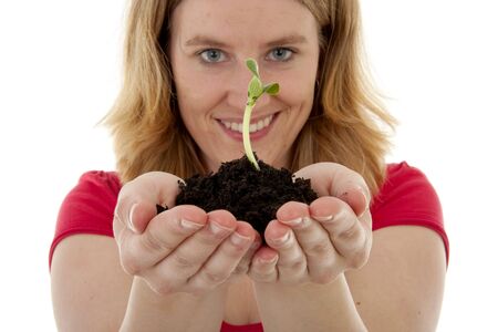 Woman is holding Pile of black garden soil with young plant for new life over white backgroundの写真素材