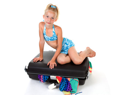 young child on stuffed suitcase over white backgroundの写真素材