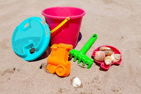 colorful plastic toys on the beach near the seaの写真素材