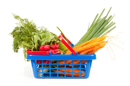 Shopping basket filled with healthy vegetables over white backgroundの写真素材