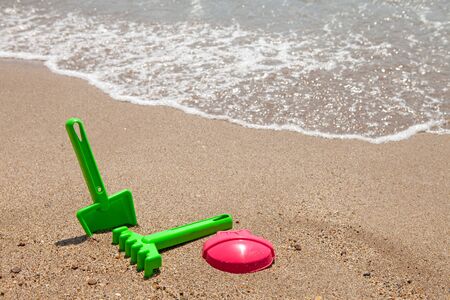 plastic colorful toys at the beach near the oceanの写真素材