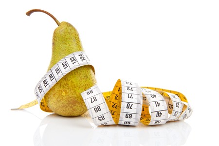 healthy diet; pear with measure tape over white backgroundの写真素材