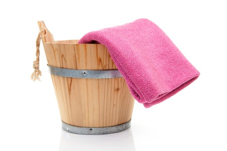 wooden bucket for spa or sauna with pink towel over white backgroundの写真素材