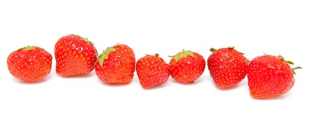 fresh strawberries in a row over white backgroundの写真素材