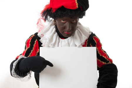 Zwarte piet ( black pete) typical Dutch character part of a traditional event celebrating the birthday of Sinterklaas in december over white background is holding empty text boardの写真素材