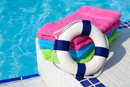 colorful towels and life buoy near the swim poolの写真素材