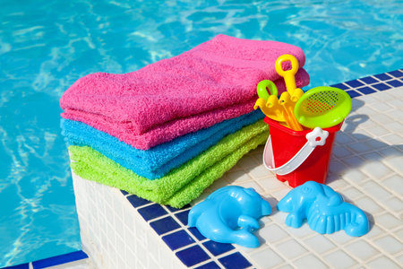 colorful towels and plastic toys near the swim poolの写真素材