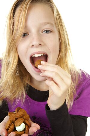 Girl with ginger nuts ( pepernoten ) for Sinterklaas, traditional in the netherlands, over white backgroundの写真素材