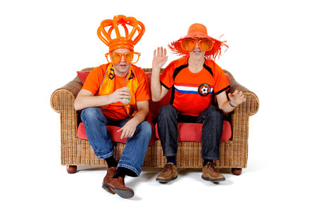 Two Dutch soccer fan watching game over white backgroundの写真素材