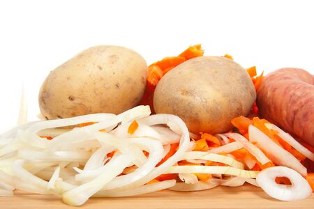 Ingredients for Dutch hutspot stew on wooden cutting board in closeup over white backgroundの写真素材