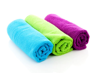 Three colorful rolled towels over white backgroundの写真素材