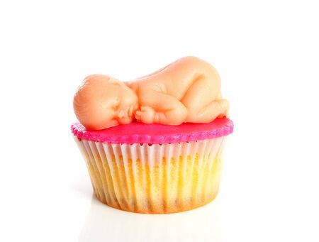Pink Birth cupcake with marzipan baby over white backgroundの写真素材