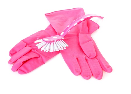 pair of pink household gloves and dish brush over white backgroundの写真素材