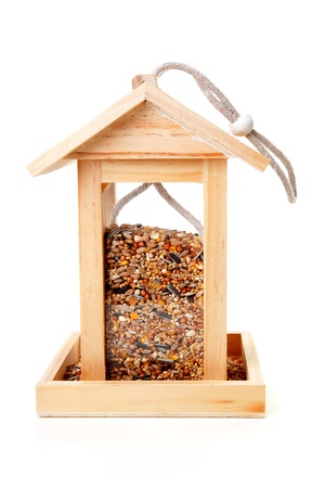 wooden bird feeder house with food over white backgroundの写真素材