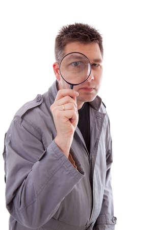 Man with raincoat is looking through magnifying glass and has a big eye over white backgroundの写真素材