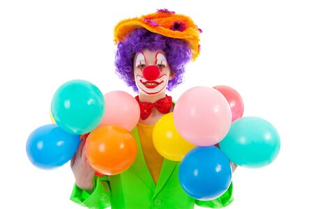 child dressed as colorful funny clown with balloons over white backgroundの写真素材
