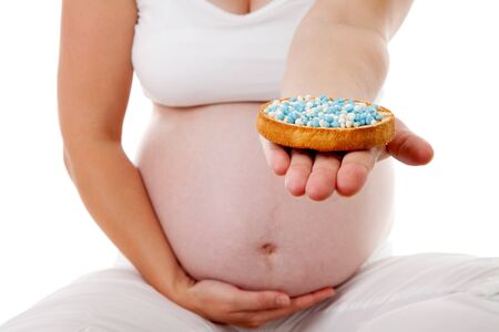 Pregnant belly with blue mice on rusk over white backgroundの写真素材