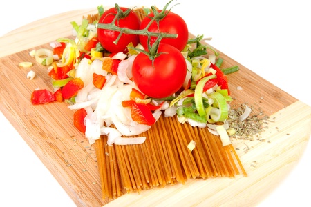 Ingredients for spaghetti on wooden cutting board over white backgroundの写真素材