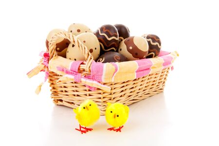 Cane basket with easter eggs over white backgroundの写真素材