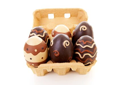 Egg carton with six decorated easter eggs over white backgroundの写真素材