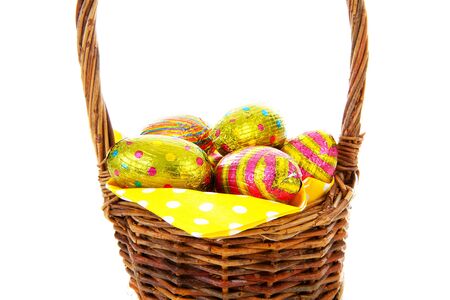 Cane basket with easter eggs in closeup over white backgroundの写真素材