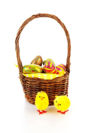 Cane basket with easter eggs over white backgroundの写真素材