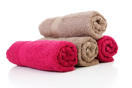 Four rolled colorful towels in red and brown over white backgroundの写真素材
