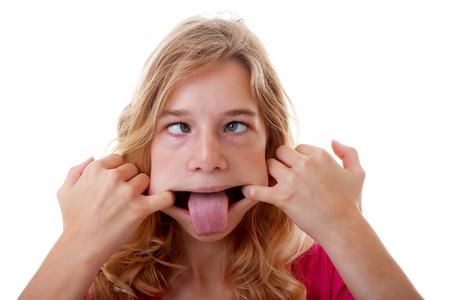girl makes funny face in closeup over white backgroundの写真素材