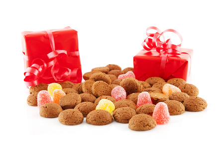 Typical dutch sweets: pepernoten (ginger nuts) and red presents for celebration at 5 december in the Netherlands over white backgroundの写真素材