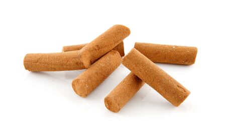 Pile of cinnamon sticks in closeup over white backgroundの写真素材